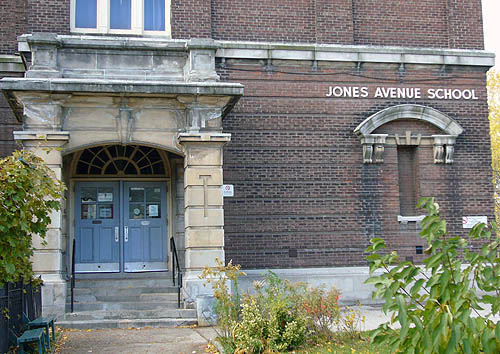 Brickbuilding is labelled JONES AVENUE SCHOOL and has masive stone portico