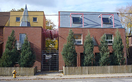 Three-storey buildings in red brick, with porthole windows and roofs in yellow and blue