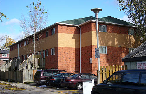 Three-storey building in red brick, witha buff-brick stripe just below the roof