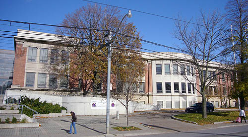 Very wide three-storey brick building with rounded centre section