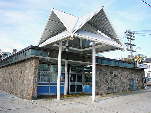 Single-storey building with stone sides, a flat roof, and giant pagodas over the recessed entrance