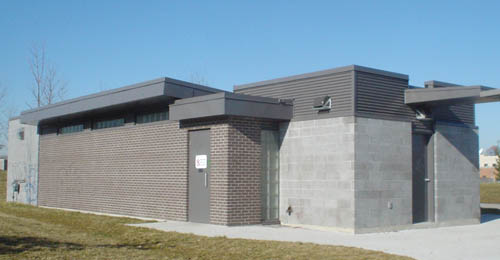 Single-storey building is made of brown brick and concrete blocks and has flat roofs at different heights