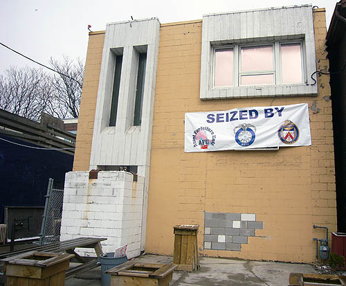 Building has no signage save for a banner reading SEIZED by and three logos